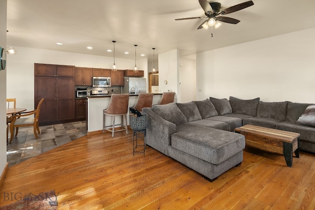 living room featuring ceiling fan and hardwood / wood-style floors