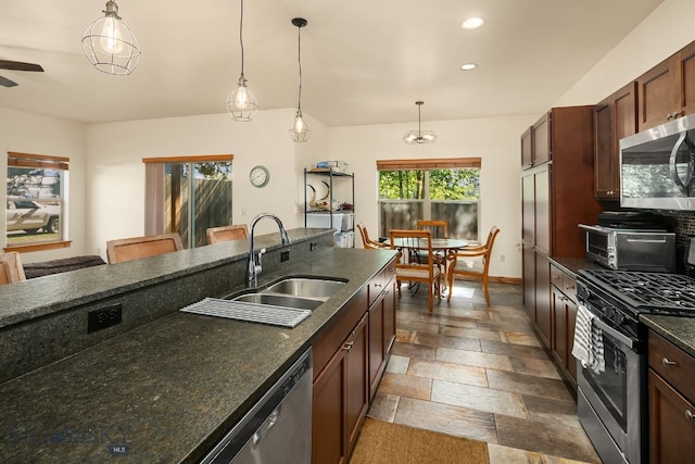 kitchen featuring ceiling fan, stainless steel appliances, hanging light fixtures, and sink