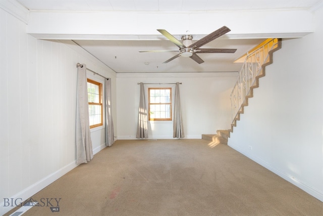 spare room with ceiling fan, beamed ceiling, carpet flooring, and crown molding