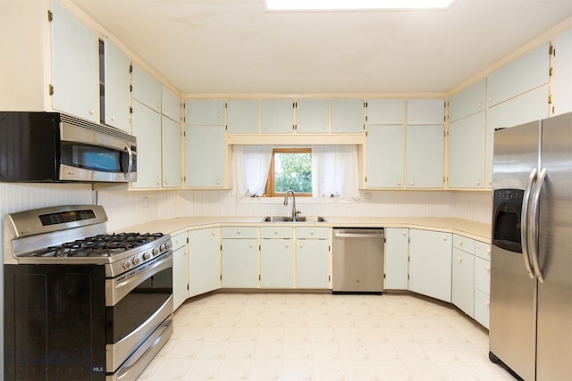 kitchen with white cabinets, appliances with stainless steel finishes, and sink