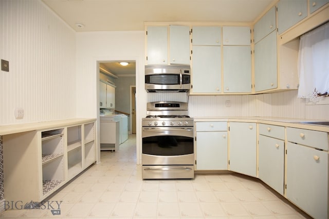 kitchen with washer / dryer, appliances with stainless steel finishes, and white cabinetry