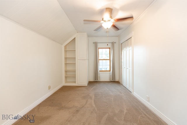 additional living space featuring vaulted ceiling, ceiling fan, built in features, and light colored carpet