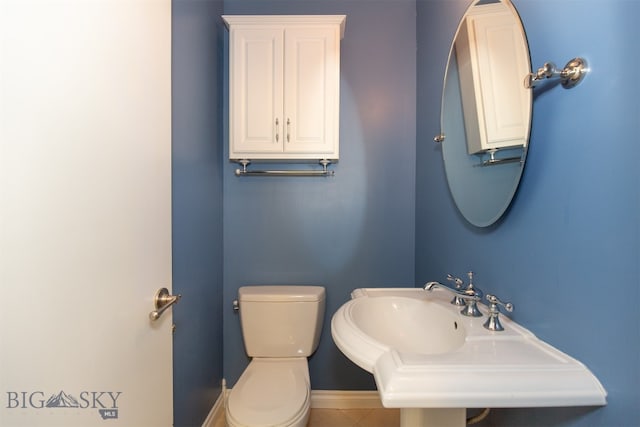 bathroom featuring toilet, sink, and tile patterned floors