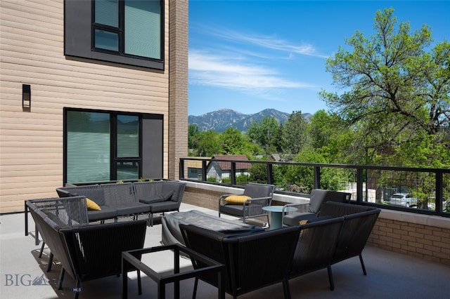 view of patio / terrace featuring a balcony, outdoor lounge area, and a mountain view