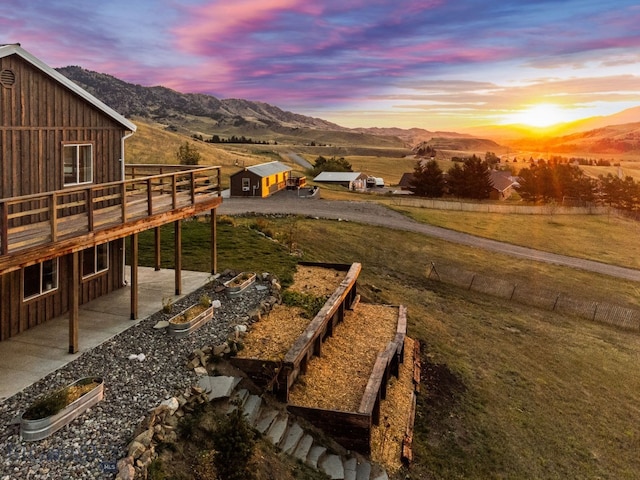 yard at dusk with a patio and a mountain view