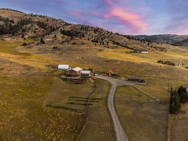 aerial view at dusk with a mountain view and a rural view