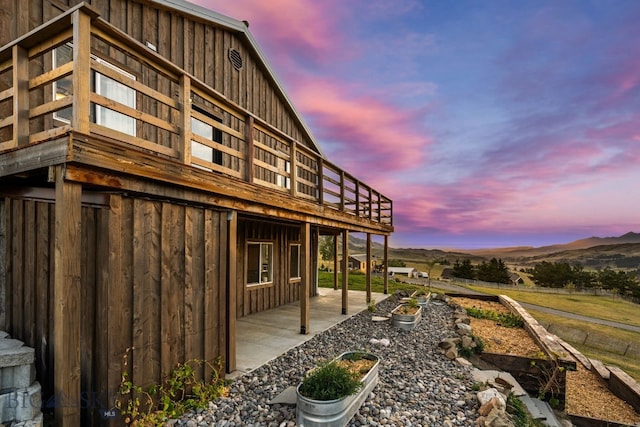 property exterior at dusk with a patio and a mountain view