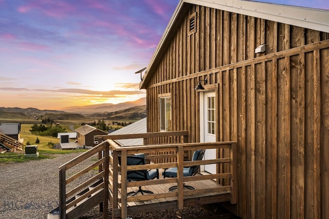 property exterior at dusk featuring a deck with mountain view