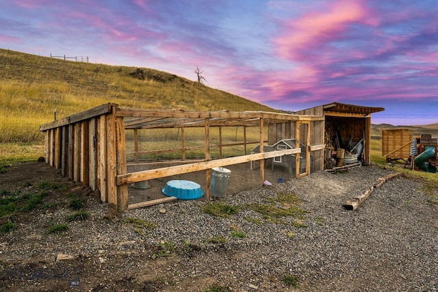 outdoor structure at dusk featuring a rural view