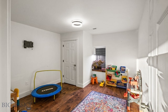 playroom with dark wood-type flooring