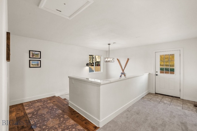 interior space with carpet and pendant lighting