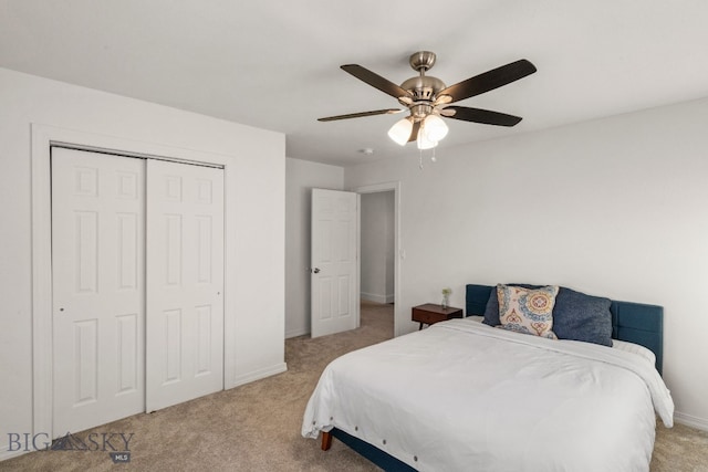 bedroom with ceiling fan, light colored carpet, and a closet