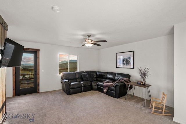 carpeted living room with ceiling fan