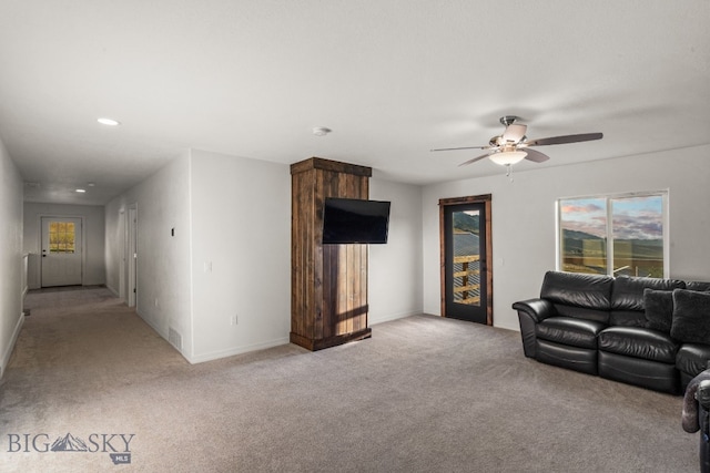 unfurnished living room featuring light carpet and ceiling fan