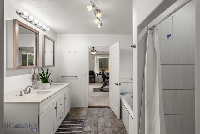 bathroom with vanity, a textured ceiling, wood-type flooring, separate shower and tub, and ceiling fan