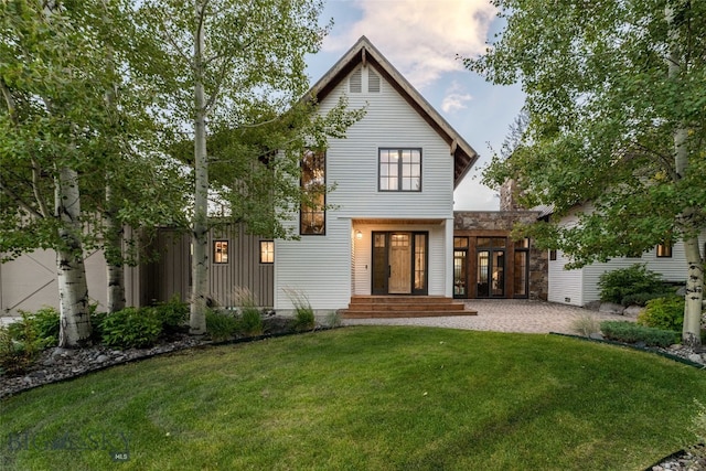 view of front of house with french doors and a lawn