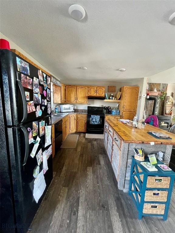 1115 E Center St, Dillon, MT 59725 - kitchen featuring black appliances, dark wood finished floors, brown cabinets, and a sink