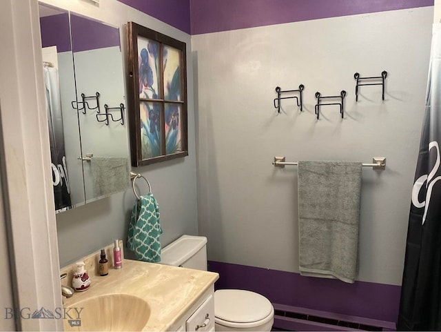 bathroom with vanity, baseboard heating, and toilet