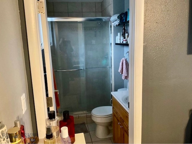 bathroom featuring tile patterned floors, walk in shower, vanity, and toilet