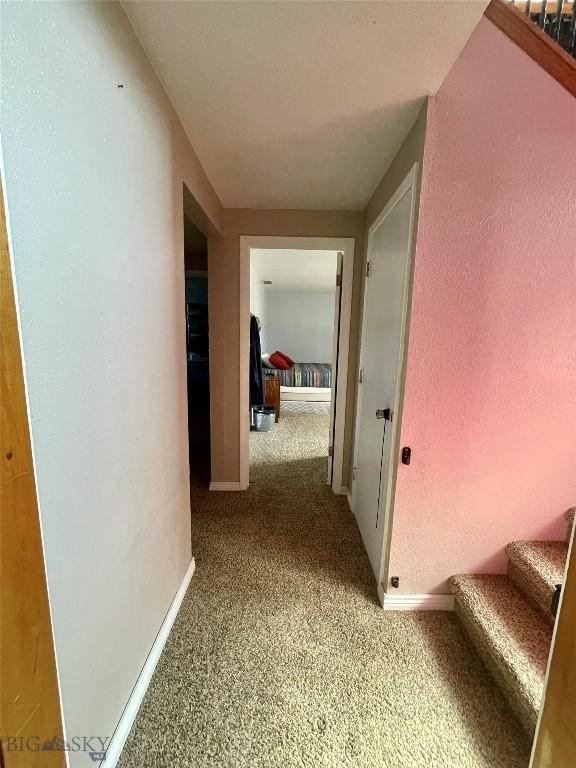 1115 E Center St, Dillon, MT 59725 - hall featuring carpet flooring, stairway, and baseboards