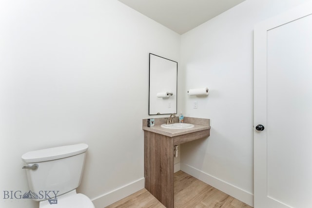 bathroom featuring toilet, hardwood / wood-style flooring, and sink