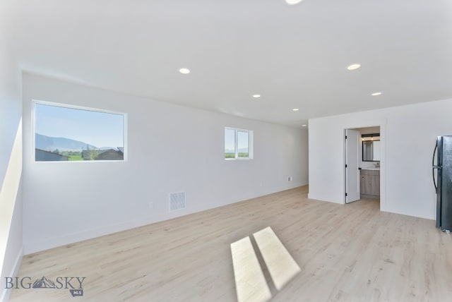 empty room with light hardwood / wood-style flooring