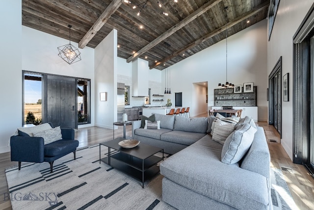 living room featuring light hardwood / wood-style floors, wood ceiling, beam ceiling, and high vaulted ceiling