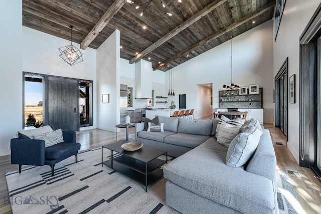 500 Stubbs Ln, Bozeman, MT 59718 - living room with high vaulted ceiling, a wood ceiling with exposed beams, light wood finished floors, and a chandelier
