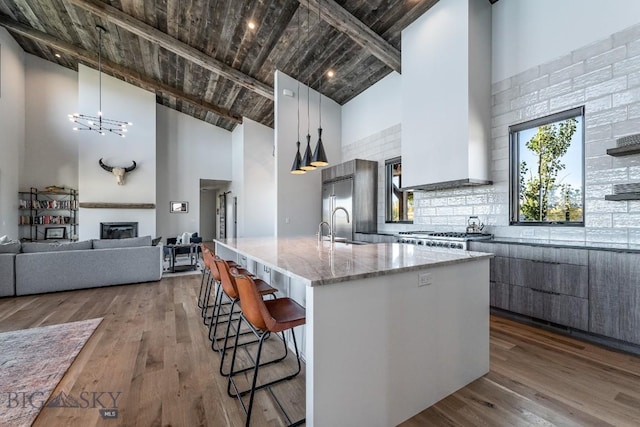 500 Stubbs Ln, Bozeman, MT 59718 - kitchen with high vaulted ceiling, a kitchen breakfast bar, a large island, a wood ceiling with exposed beams, and light stone counters