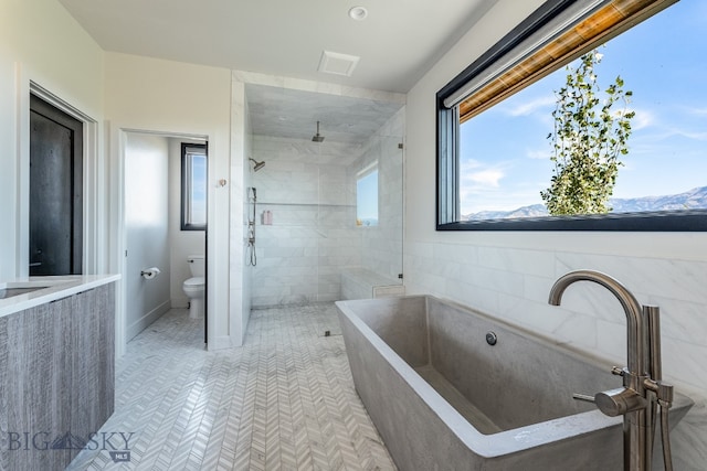 bathroom with tile patterned flooring, toilet, a mountain view, and shower with separate bathtub