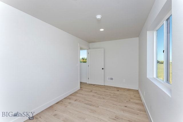 spare room with light hardwood / wood-style floors and a healthy amount of sunlight