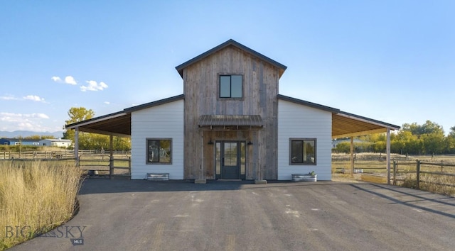 500 Stubbs Ln, Bozeman, MT 59718 - view of front of house featuring driveway, a carport, board and batten siding, an exterior structure, and an outdoor structure