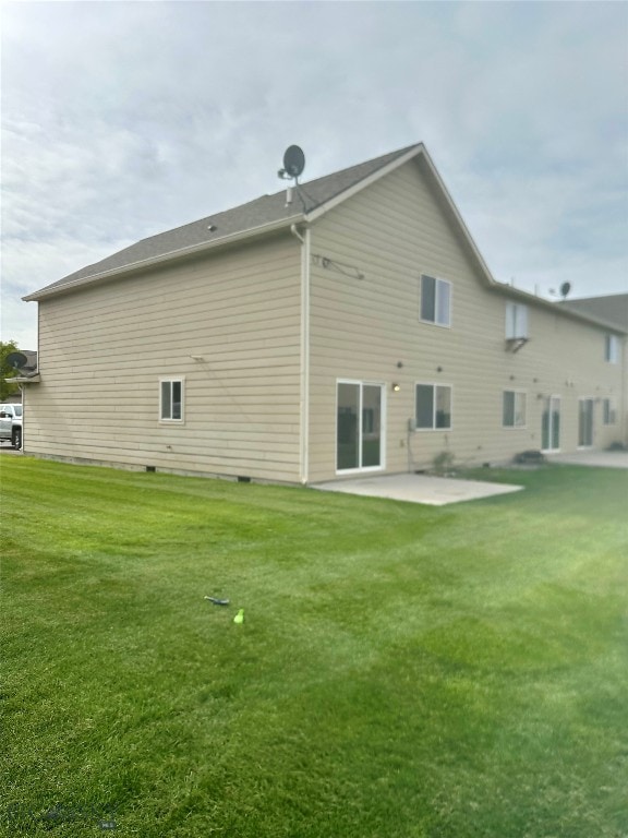 rear view of property with a yard and a patio area