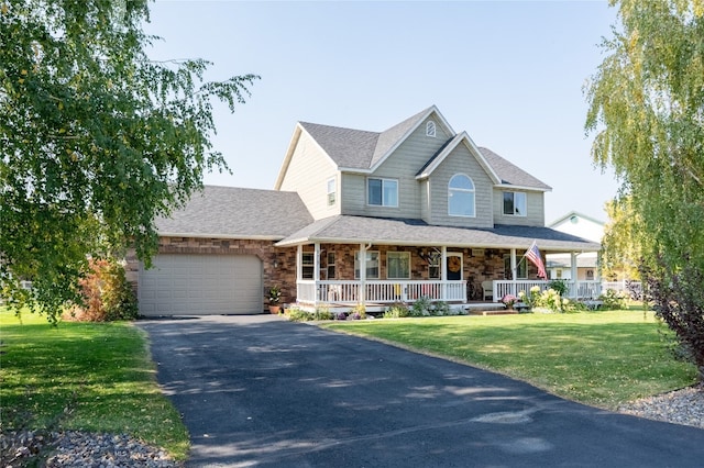 view of front of home featuring a front lawn, a garage, and covered porch