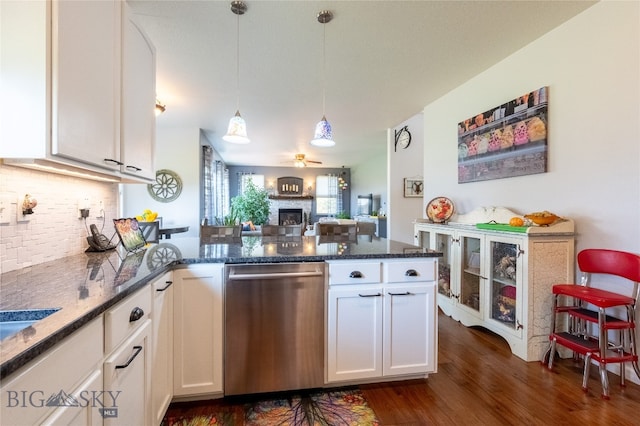 kitchen with white cabinets, dishwasher, dark hardwood / wood-style flooring, decorative light fixtures, and dark stone counters