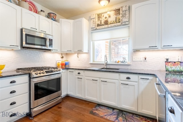 kitchen with appliances with stainless steel finishes, white cabinetry, and dark wood-type flooring