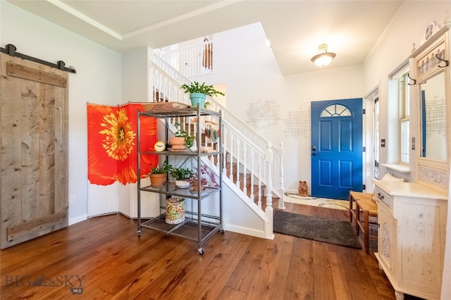 foyer entrance with hardwood / wood-style flooring and a barn door