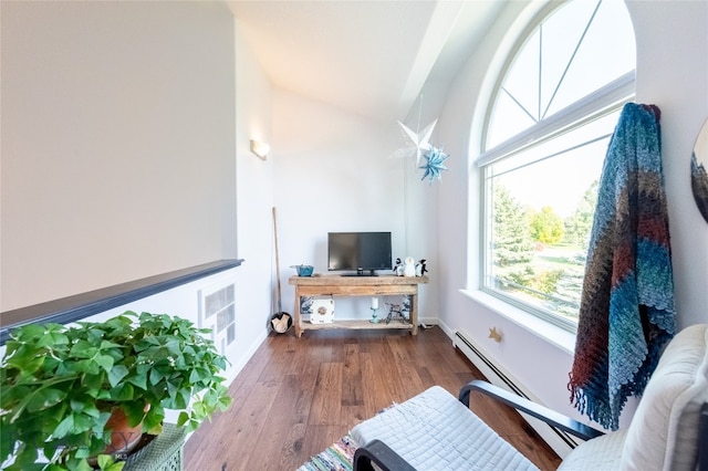 living room featuring vaulted ceiling, baseboard heating, and hardwood / wood-style flooring