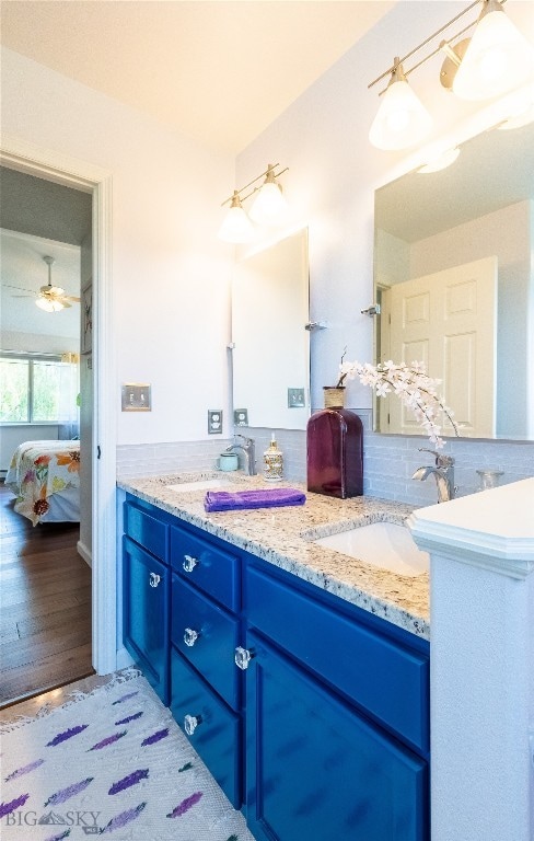 bathroom featuring hardwood / wood-style floors, ceiling fan, vanity, and tasteful backsplash