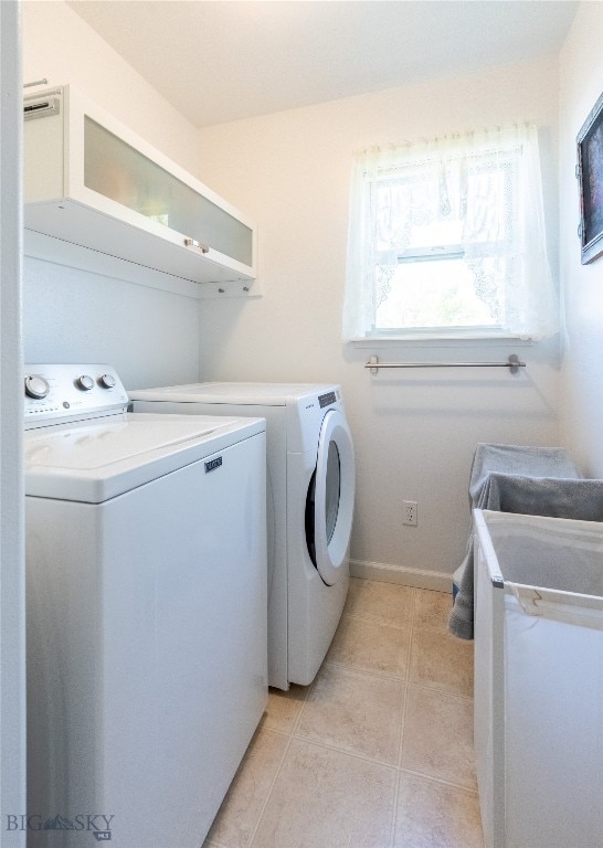 washroom with independent washer and dryer and light tile patterned floors