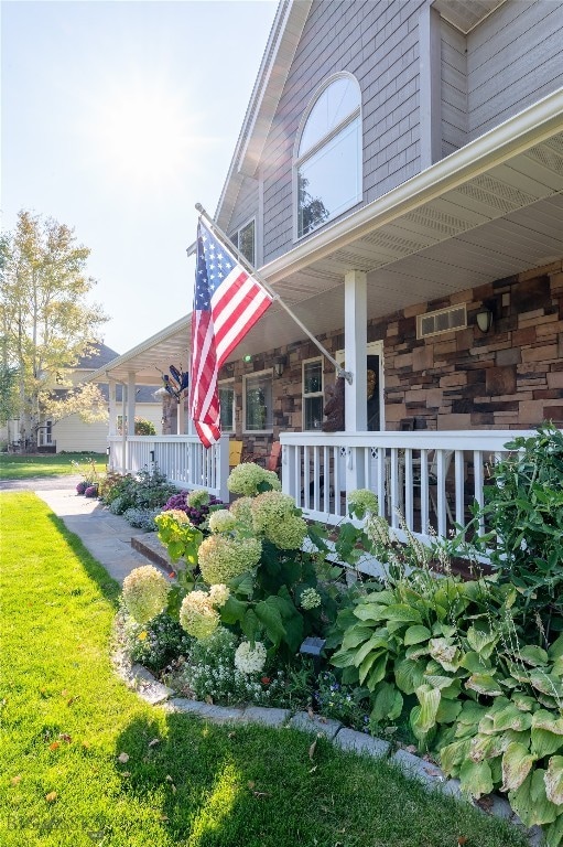 view of side of property with covered porch and a yard