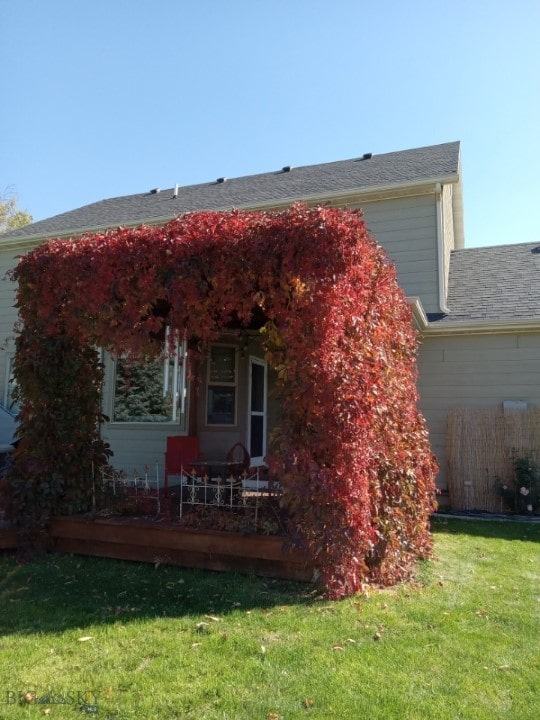 back of house featuring a lawn and a deck