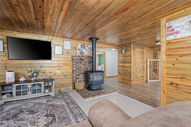 living room featuring wood ceiling, wood walls, hardwood / wood-style floors, and a wood stove