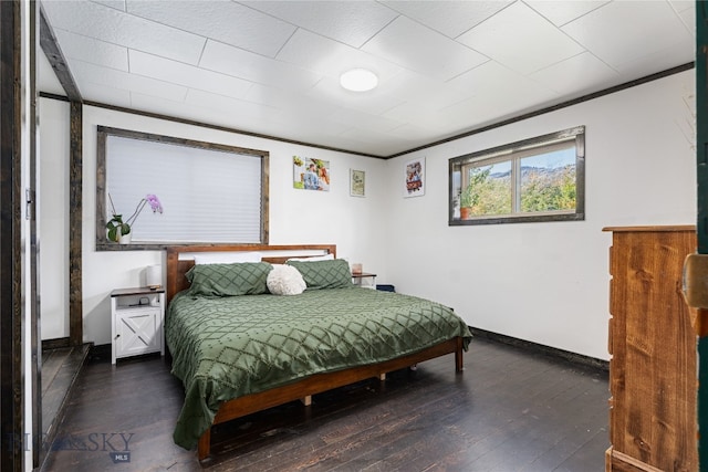 bedroom featuring ornamental molding and dark hardwood / wood-style flooring