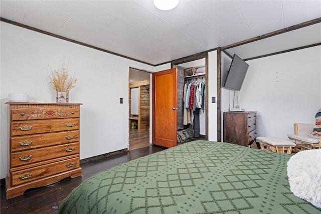 bedroom with ornamental molding, dark hardwood / wood-style floors, and a closet