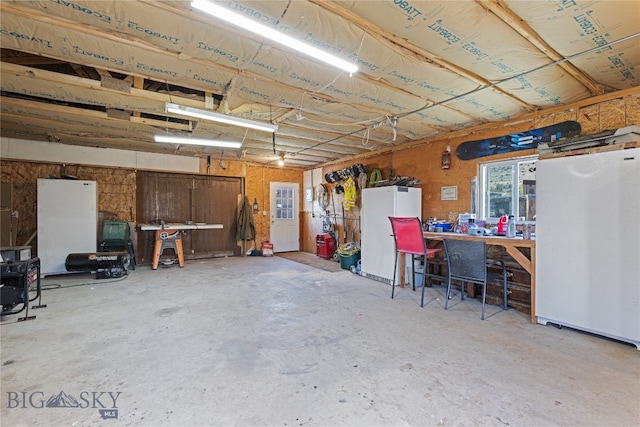 garage featuring a workshop area and white fridge