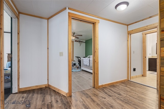 corridor featuring wood-type flooring and crown molding