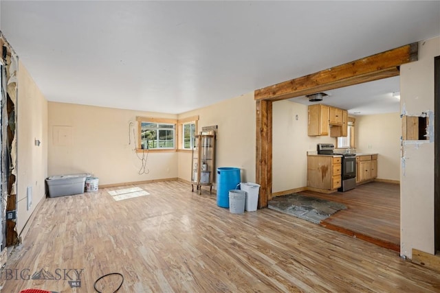 unfurnished living room featuring baseboards and light wood-style flooring