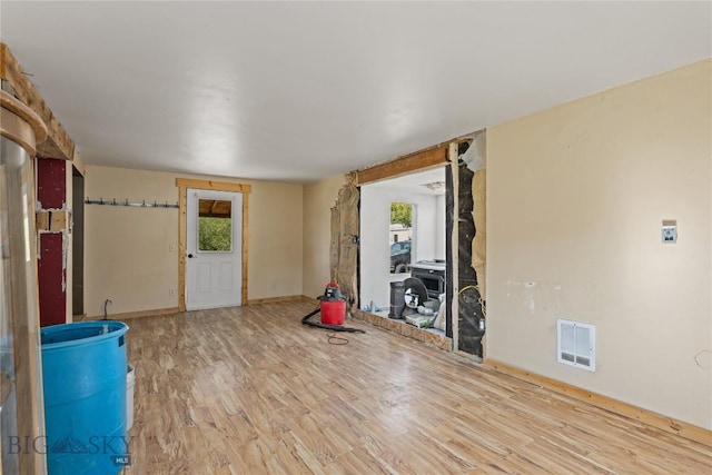 interior space featuring visible vents, baseboards, wood finished floors, and a healthy amount of sunlight
