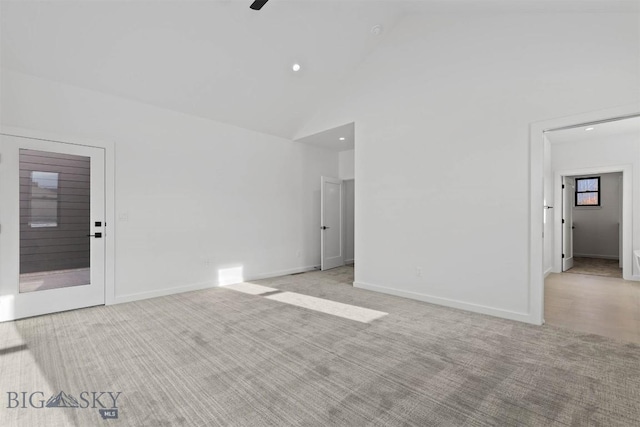 carpeted empty room featuring high vaulted ceiling